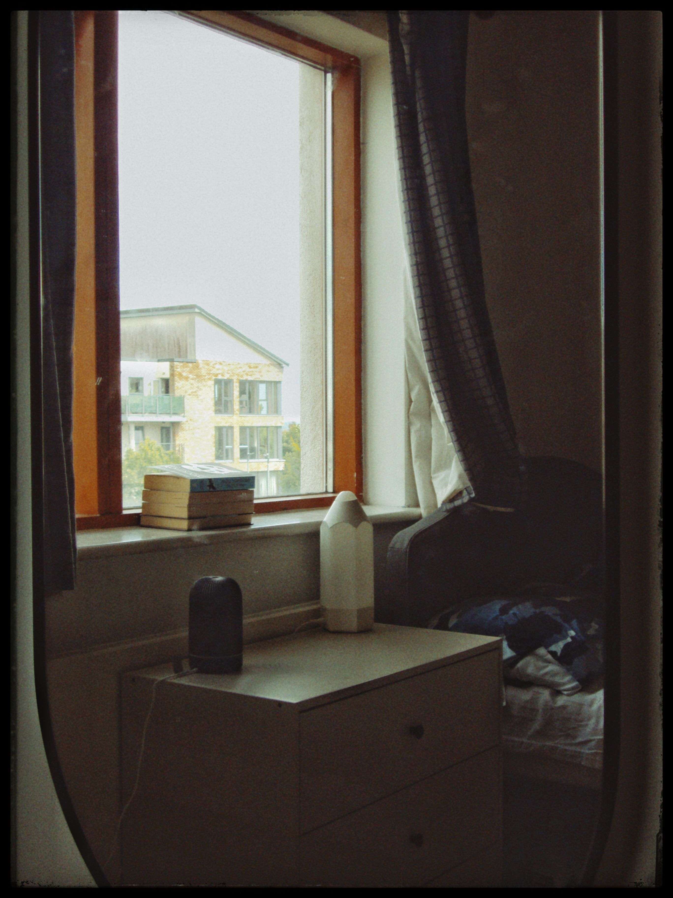 A 2000s style photo of a bedroom window through a mirror.